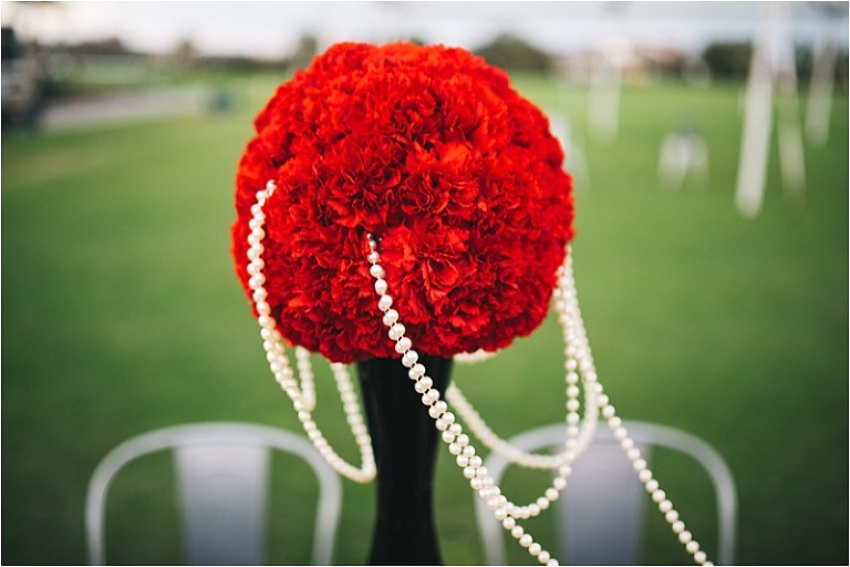 red floral bouquet centerpiece white pearls windy black vase