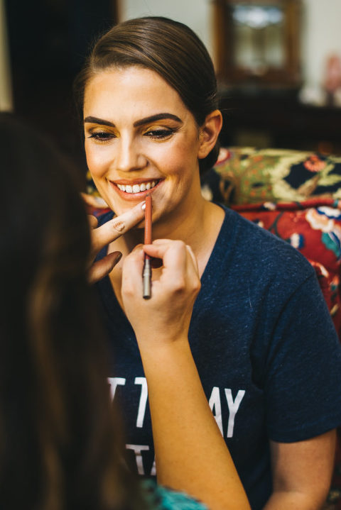 bride smiling while shes getting makeup done