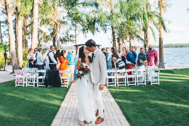 couple kissing as they walk up the aisle