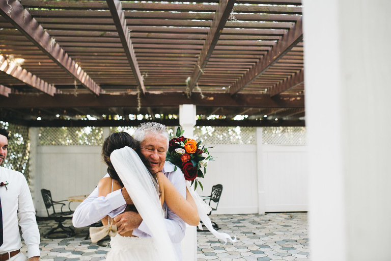 father of the groom hugging bride