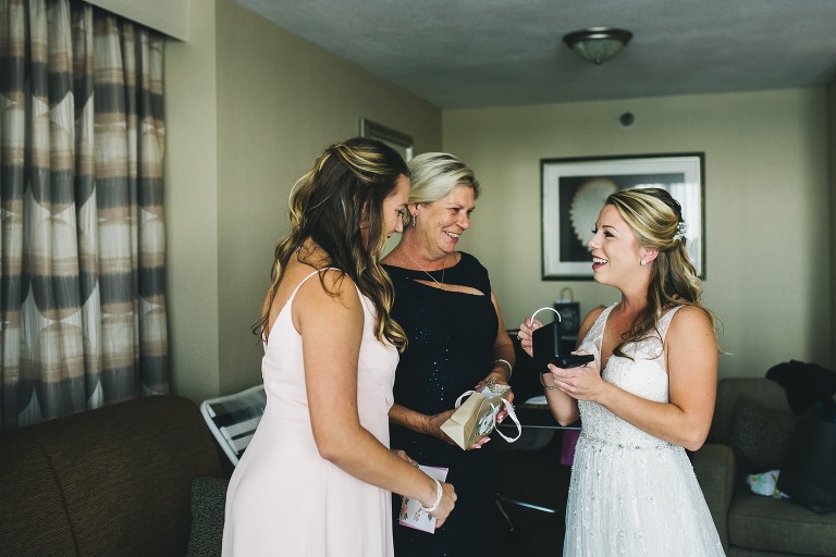 maid of honor and mother of the bride giving gift to brides