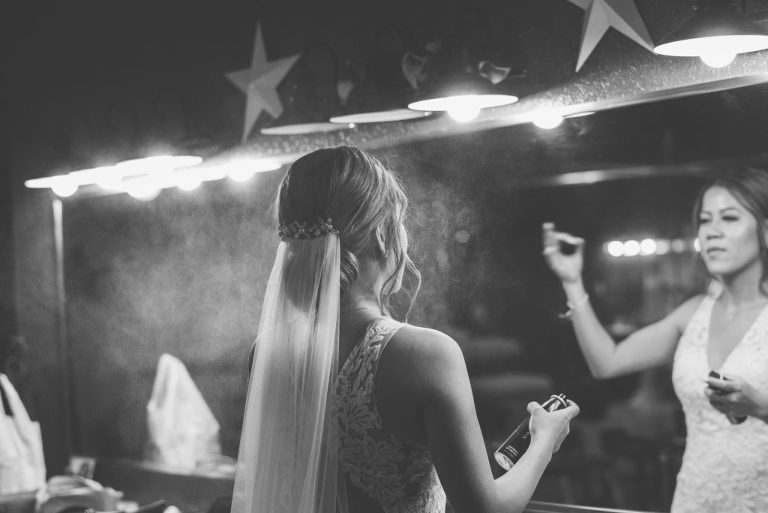 bride putting on hair spray